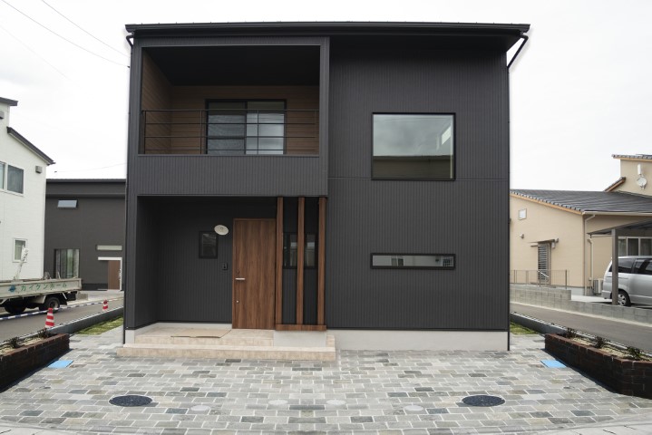 黒の外壁と木目玄関ドアが印象的な住宅外観